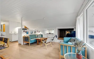 a living room with blue chairs and a table at Holiday Home Klydevej Hurup Thy Xi in Sindrup