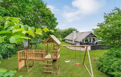 a playground in a yard with a house at Holiday Home Klydevej Hurup Thy Xi in Sindrup