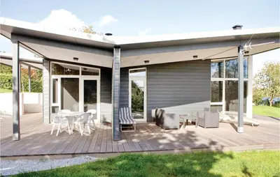 a house with a deck with a table and chairs at Holiday Home Følvigvej Roslev I in Roslev