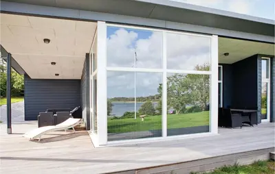 a house with a large glass window on a patio at Holiday Home Følvigvej Roslev I in Roslev