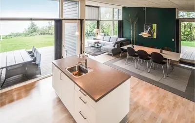 a kitchen and living room with a table and chairs at Holiday Home Følvigvej Roslev I in Roslev