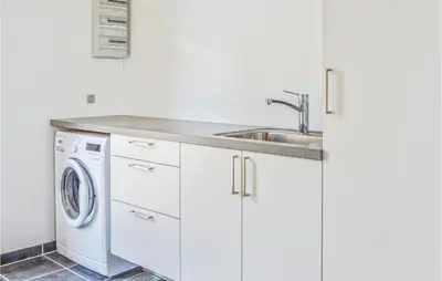 a white kitchen with a sink and a washing machine at Holiday Home Følvigvej Roslev I in Roslev