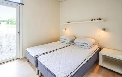 a bedroom with a bed with two pillows on it at Holiday Home Følvigvej Roslev I in Roslev