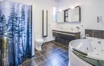 a bathroom with a tub and a toilet and a sink at Holiday Home Følvigvej Roslev I in Roslev