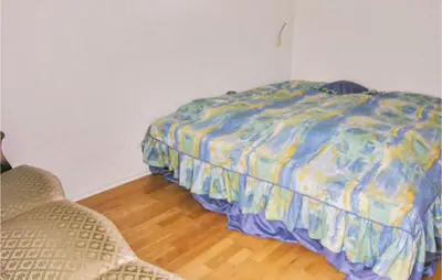 a bed in a room with two chairs next to it at Holiday Home Bakkegårdsvej in Vesløs