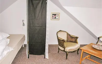 a bedroom with a bed and a chair and a table at Holiday Home Bakkegårdsvej in Vesløs