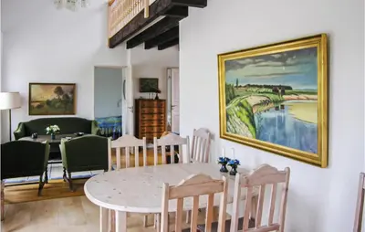 a dining room with a table and a painting on the wall at Holiday Home Bakkegårdsvej in Vesløs