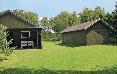 an old barn with a bench in a yard at Holiday Home Kraghøjvej Nykøbing M Ix in Hesselbjerg