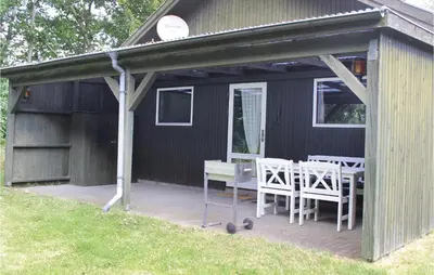 a covered patio with a table and chairs on it at Holiday Home Kraghøjvej Nykøbing M Ix in Hesselbjerg