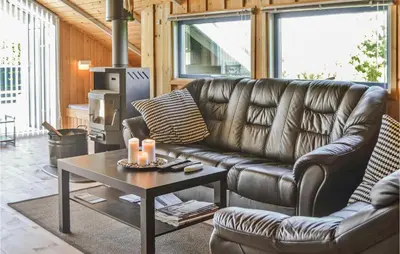 a living room with a leather couch and a coffee table at Holiday Home Sulevej Hurup Thy Xi in Sindrup
