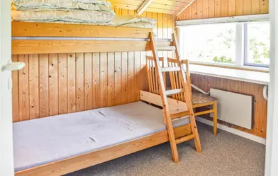 a bunk bed and a ladder in a cabin with a window at Holiday Home Sulevej Hurup Thy Xi in Sindrup