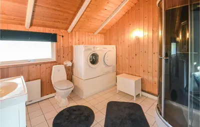 a bathroom with a toilet and a washing machine at Holiday Home Sulevej Hurup Thy Xi in Sindrup