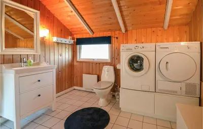 a bathroom with a washing machine and a toilet at Holiday Home Sulevej Hurup Thy Xi in Sindrup