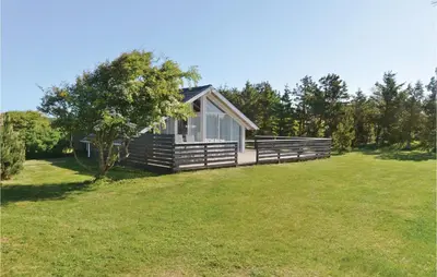 a small cabin in a field with a grassy yard at Holiday Home Sulevej Hurup Thy Xi in Sindrup