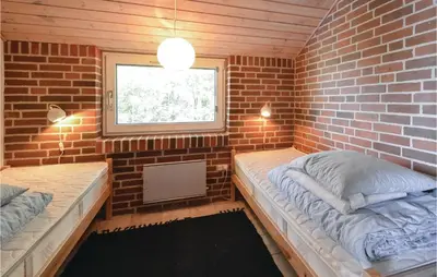 a small room with two beds and a window at Holiday Home Grynderup Strand Roslev in Roslev