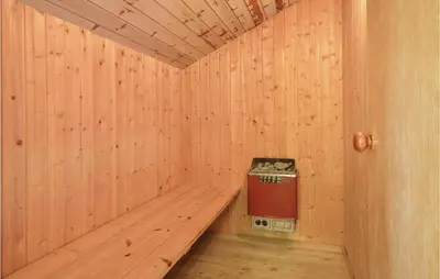 a wooden sauna with a trash can in it at Holiday Home Grynderup Strand Roslev in Roslev