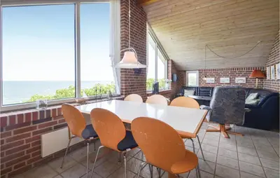 a dining room with a white table and chairs at Holiday Home Grynderup Strand Roslev in Roslev