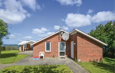 a small brick house with a satellite at Holiday Home Grynderup Strand Roslev in Roslev