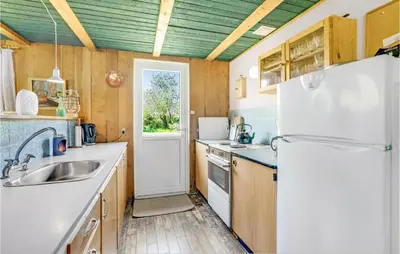 a kitchen with a refrigerator and a sink at Holiday Home Sølvmågevej Hurup Thy Ii in Sindrup