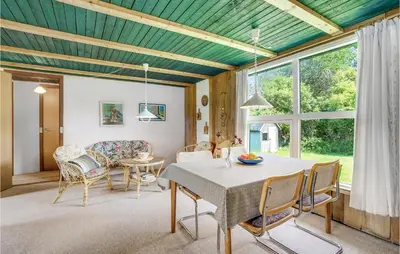 a living room with a table and chairs at Holiday Home Sølvmågevej Hurup Thy Ii in Sindrup
