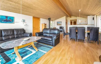 a living room with a couch and a table at Holiday Home Limfjordsvangen Snedsted Vi in Snedsted