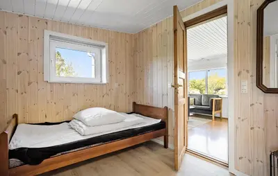 a bedroom with a bed in a room with a window at Holiday Home Pinen Roslev X in Roslev