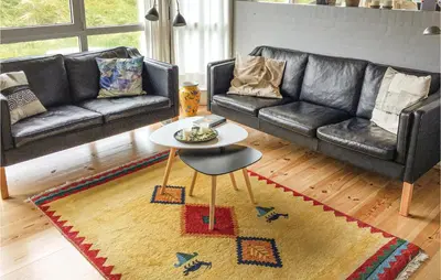 a living room with a couch and a table at Holiday Home Svenstibakkevej I in Frøstrup