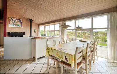a kitchen and dining room with a table and chairs at Holiday Home Svenstibakkevej I in Frøstrup