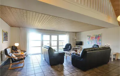 a living room with couches and a table and chairs at Holiday Home Glombak in Vesløs
