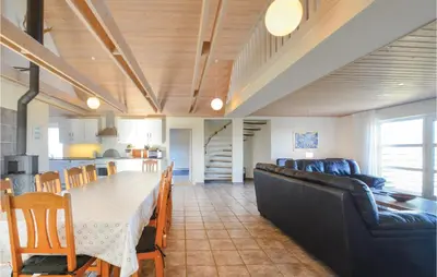 a living room with a long table and a couch at Holiday Home Glombak in Vesløs