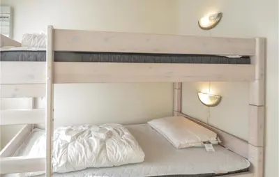 two bunk beds in a small room with a bed at Holiday Home Glombak in Vesløs