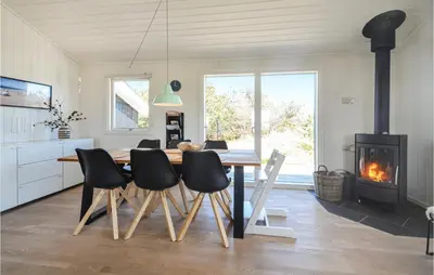a dining room with a table and chairs and a fireplace at Holiday Home Johnsvej Thisted V in Thisted