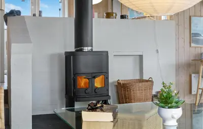 a black stove in a room with a table at Holiday Home Kløvborgsti Thisted Ix in Thisted