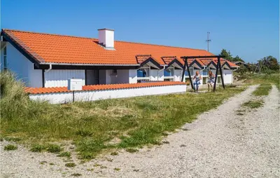 two people standing in front of a house at Amazing Home In Thisted With Sauna in Thisted