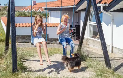 two young girls sitting on swings with a dog at Amazing Home In Thisted With Sauna in Thisted