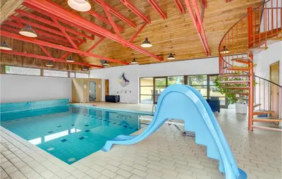 a swimming pool with a slide in a building at Rishøj in Løgstrup