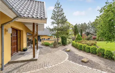 a house with a brick walkway next to a building at Rishøj in Løgstrup