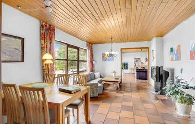 a dining room and living room with a wooden ceiling at Rishøj in Løgstrup