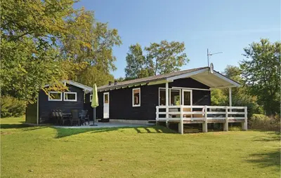 a black house with a white fence in front of it at Holiday Home Fjordparken Farsø Iv in Farsø