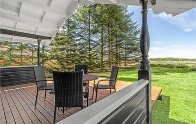 a deck with chairs and a table and an umbrella at Holiday Home Venøvej Højslev Denm in Højslev