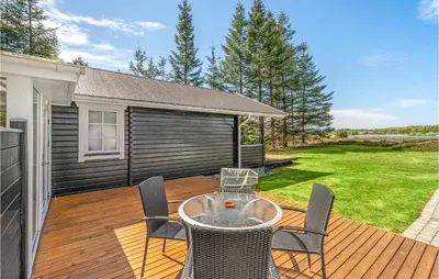 a patio with a table and chairs on a deck at Holiday Home Venøvej Højslev Denm in Højslev