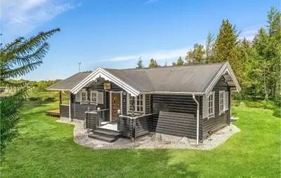 a small cabin with a porch on a green lawn at Holiday Home Venøvej Højslev Denm in Højslev