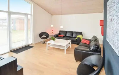 a living room with a couch and a table at Holiday Home Bronzehøjen Højslev in Højslev