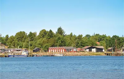 a group of houses on the shore of a lake at Holiday Home Bronzehøjen Højslev in Højslev