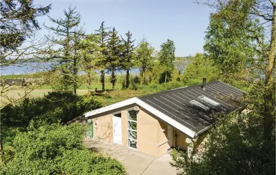 a small house with a metal roof in a field at Holiday Home Hesselvej in Farsø