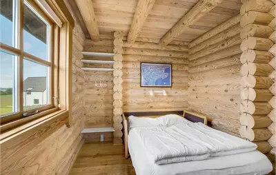 a bed in a log cabin with a window at Holiday Home Husvej in Fur