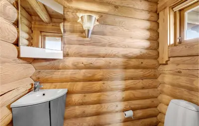a wooden bathroom with a toilet and a sink at Holiday Home Husvej in Fur