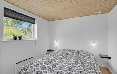 a white bedroom with a bed and a window at Holiday Home Marthasvej in Løgstør