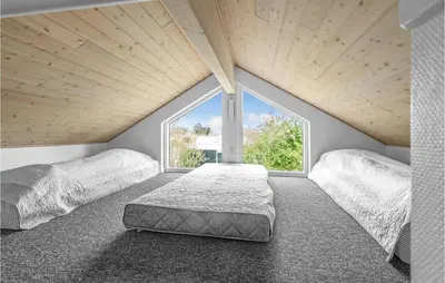 two beds in a room with a large window at Holiday Home Marthasvej in Løgstør