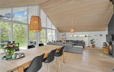 a dining room and living room with a table and chairs at Holiday Home Marthasvej in Løgstør